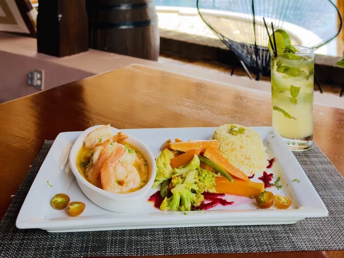 Garlic shrimp and a lime-and-mint drink at the bar, with the pool behind