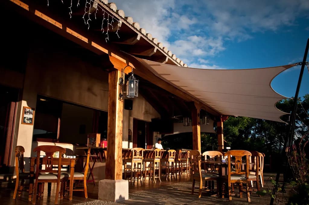 The Terraza de Palermo dining room under a sail shade, set for lunch
