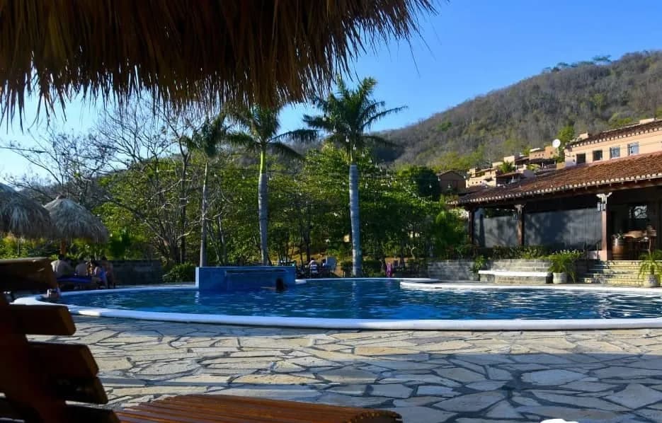 Loungers beside the pool with the hills behind