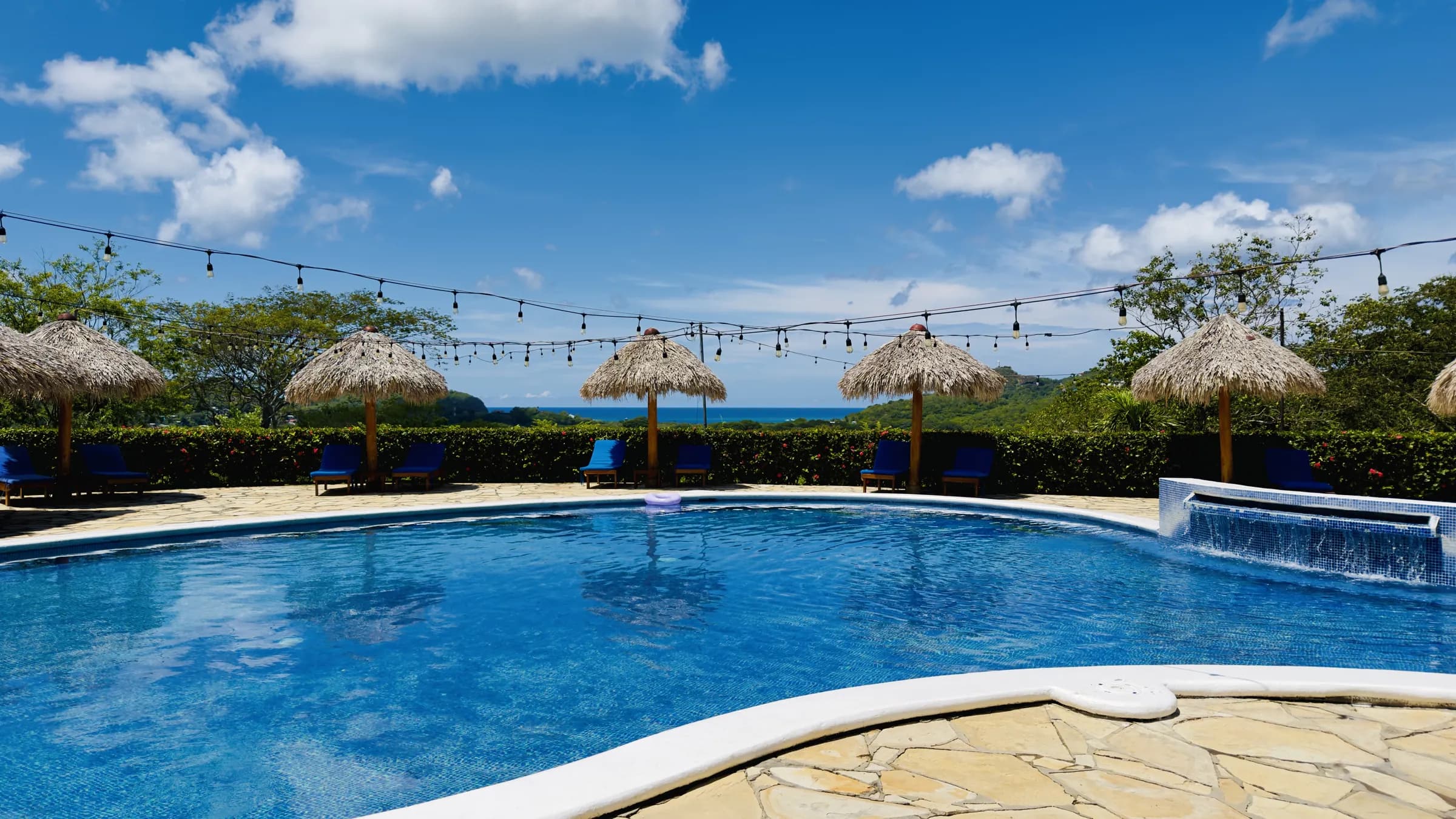 The pool with palapa umbrellas and the Pacific on the horizon